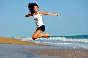 woman jumping in the air on a beach