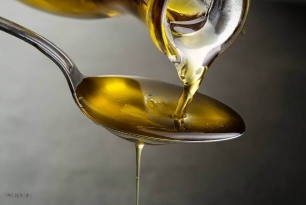 C60 Olive Oil being poured on to a spoon
